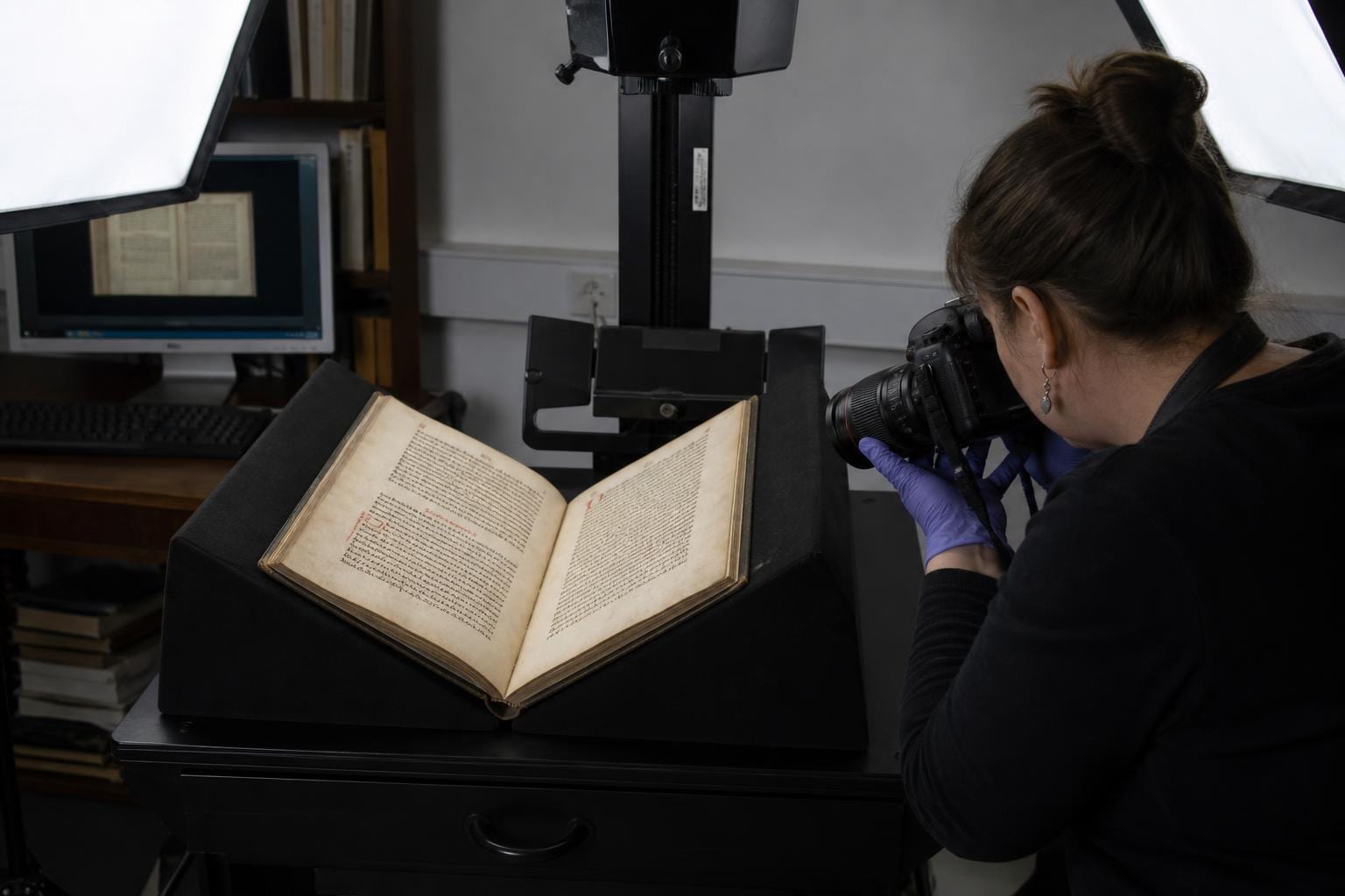 archivist photographing old manuscript copy stand